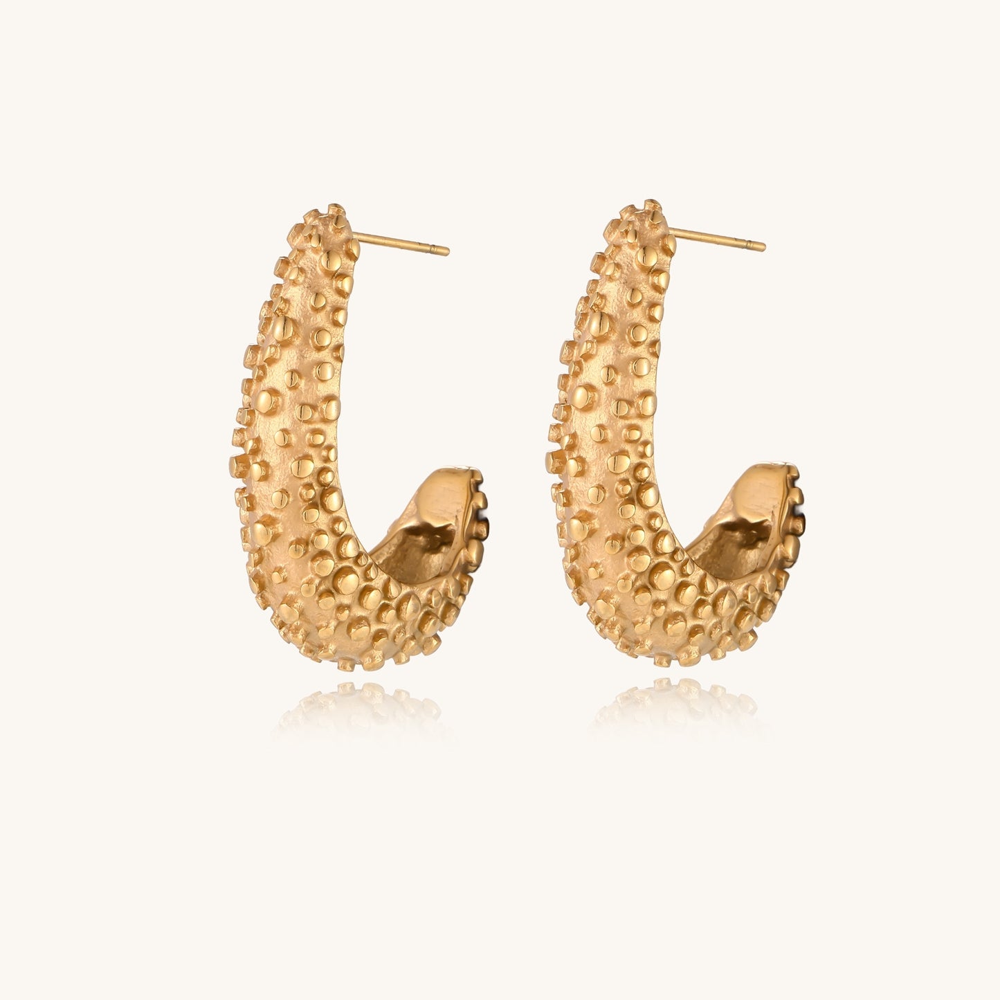Pair of gold-plated hoop earrings with raised dotted texture surface shown from multiple angles on white background.