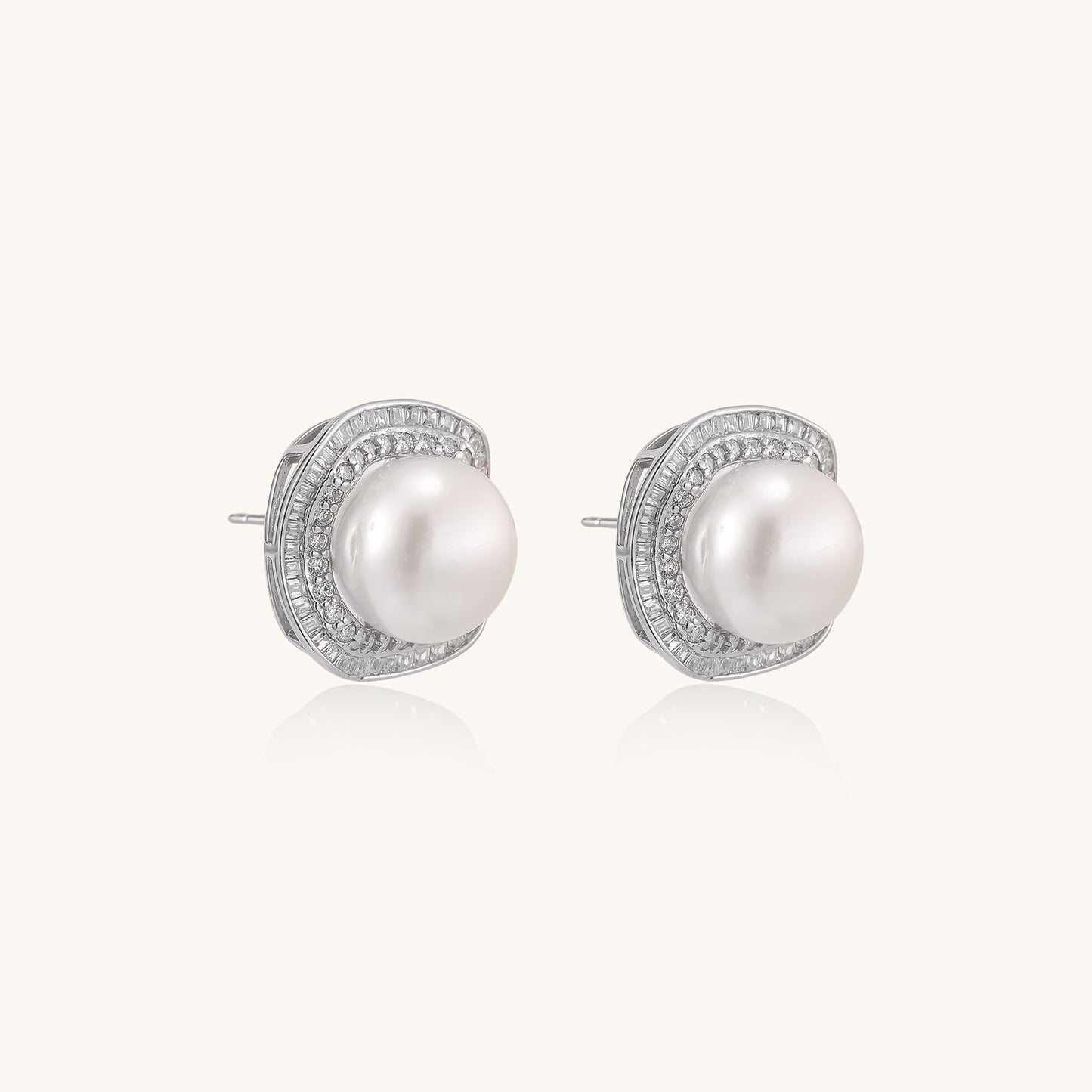 Sterling silver stud earrings with round freshwater pearls surrounded by sparkling crystal halos on white background.