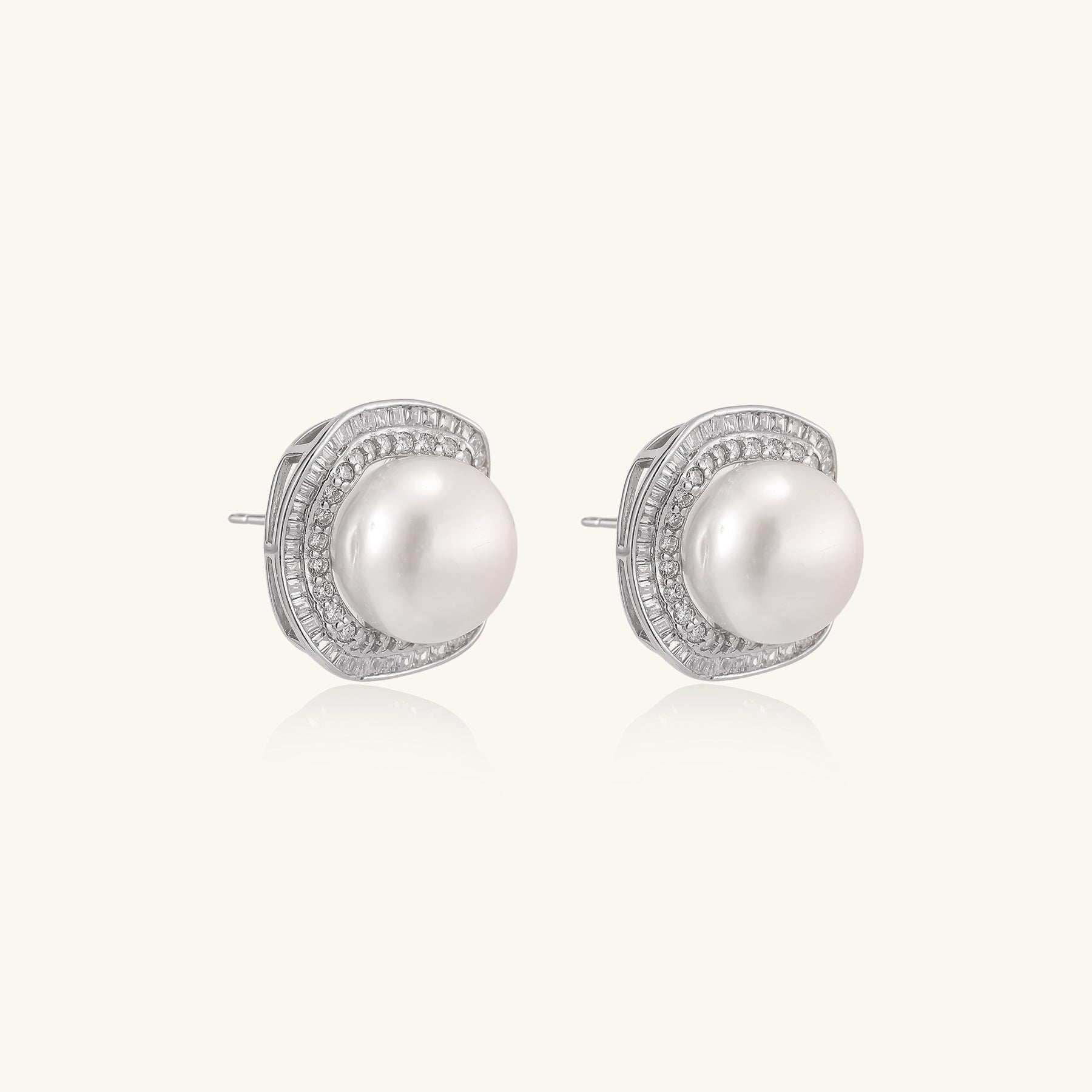 Sterling silver stud earrings with round freshwater pearls surrounded by sparkling crystal halos on white background.
