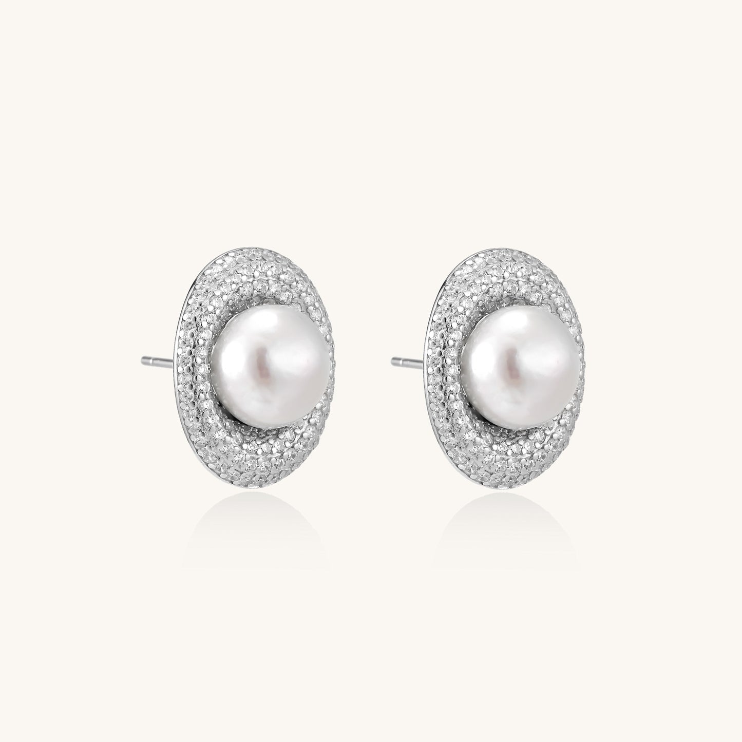Sterling silver stud earrings with freshwater pearls surrounded by sparkling pavé crystals on white background.