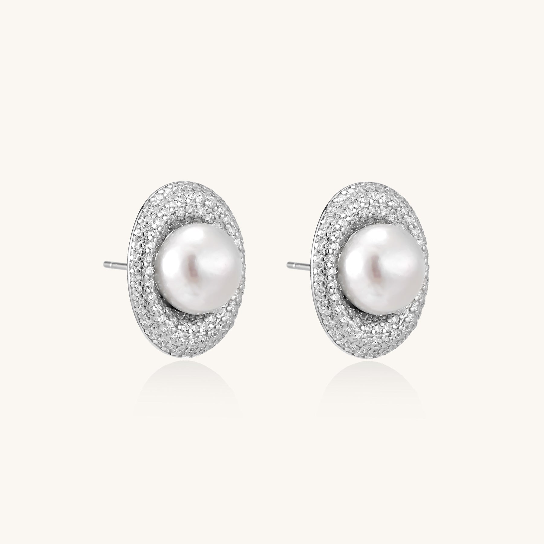 Sterling silver stud earrings with freshwater pearls surrounded by sparkling pavé crystals on white background.