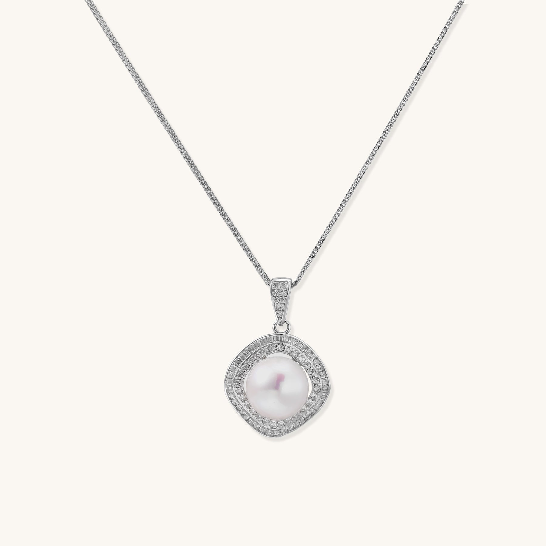 Sterling silver necklace with geometric halo setting surrounding a 10mm freshwater pearl on white background.