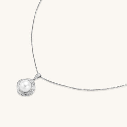 Sterling silver necklace with geometric halo setting surrounding a 10mm freshwater pearl on white background.