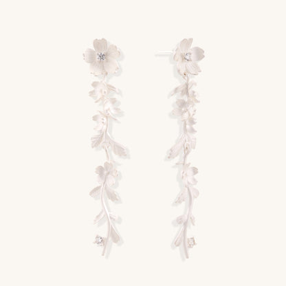 Pair of sterling silver dangle earrings with intricate leaf vine patterns and crystal accents on white background.