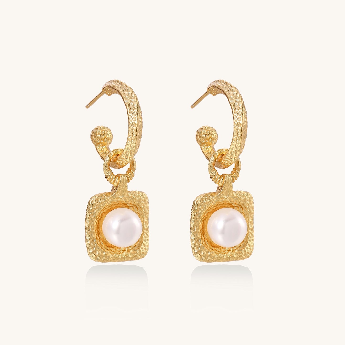 Gold-plated textured hoop earrings with square pendants containing freshwater pearls on white background