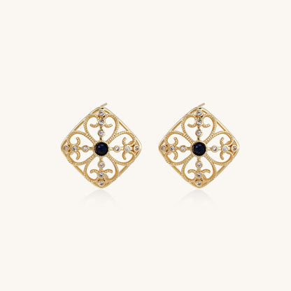 Ornate 18K gold plated stud earrings with intricate filigree design and central lapis lazuli stones on cream background.
