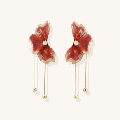 Statement drop earrings with coral-red enamel flower petals, gold-plated brass, and mother-of-pearl centers on white background