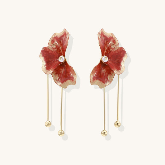 Statement drop earrings with coral-red enamel flower petals, gold-plated brass, and mother-of-pearl centers on white background