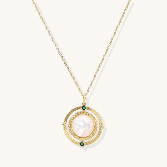 Gold-plated pendant necklace with circular orbital design, iridescent mother-of-pearl center and green zirconia accents