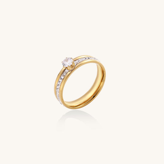 14K gold plated ring with center rhinestone and accent stones along the band on white background.