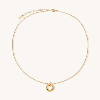 Close-up of a gold-plated stainless steel necklace with interlocking twisted ring pendant on white background