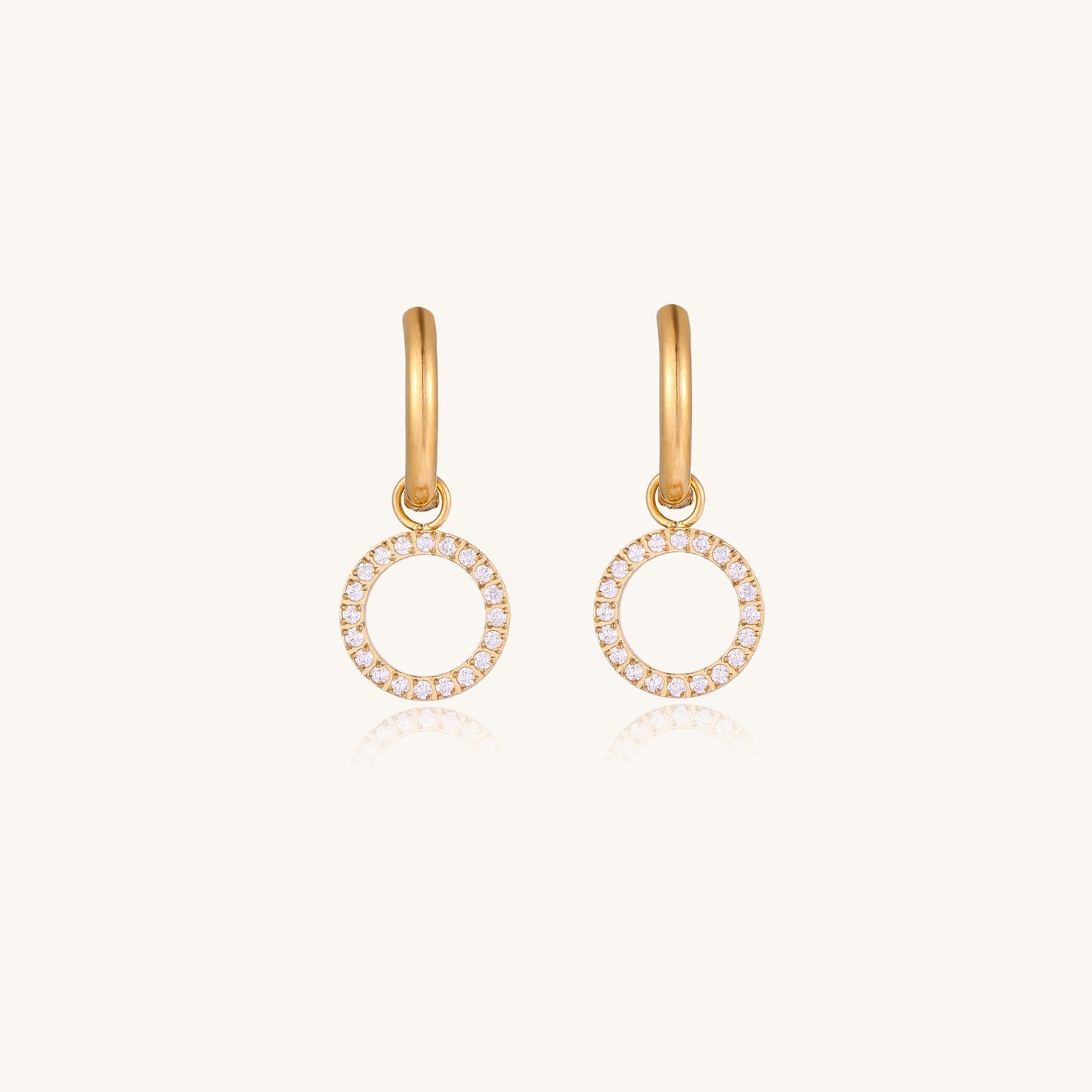Gold-plated hoop earrings with circular cubic zirconia charm dangles displayed on neutral background.