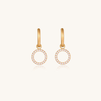 Gold-plated hoop earrings with circular cubic zirconia charm dangles displayed on neutral background.