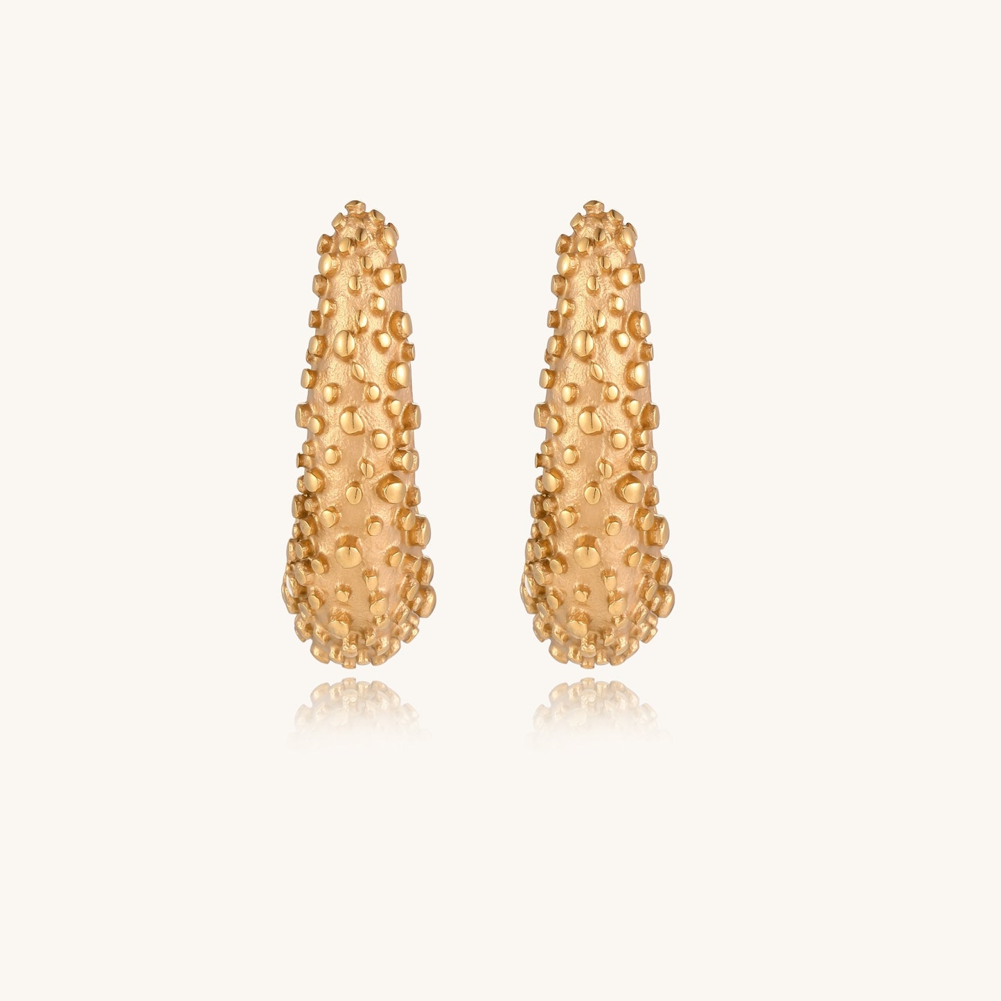Pair of gold-plated hoop earrings with raised dotted texture surface shown from multiple angles on white background.