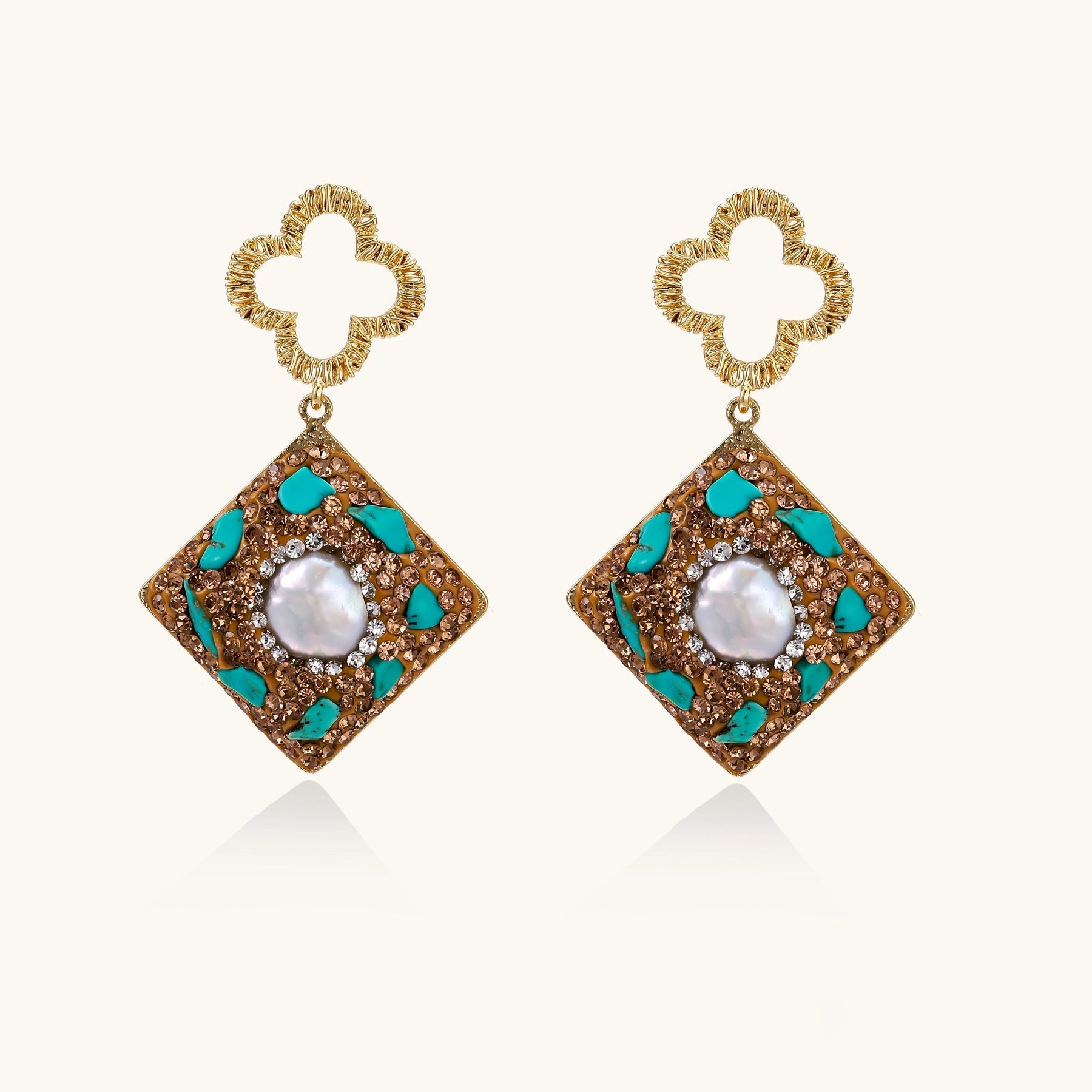Gold quatrefoil stud earrings with ornate square pendants featuring turquoise stones and freshwater pearls