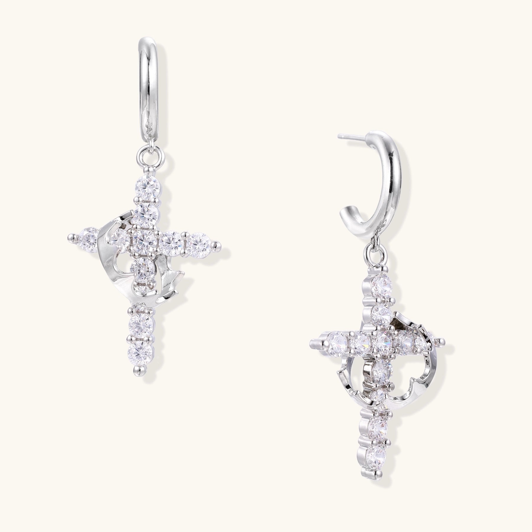 Ornate cross dangle earrings with zirconia stones and gold-plated brass construction on white background.