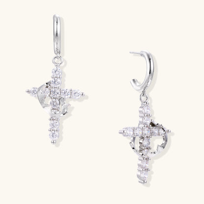 Ornate cross dangle earrings with zirconia stones and gold-plated brass construction on white background.