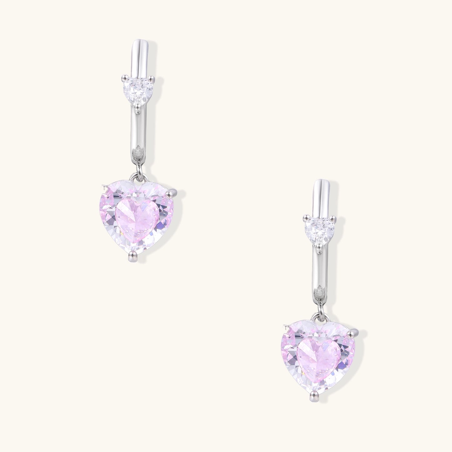 Elegant drop earrings featuring pink heart-shaped zirconia stones with clear accent gems in gold-plated settings