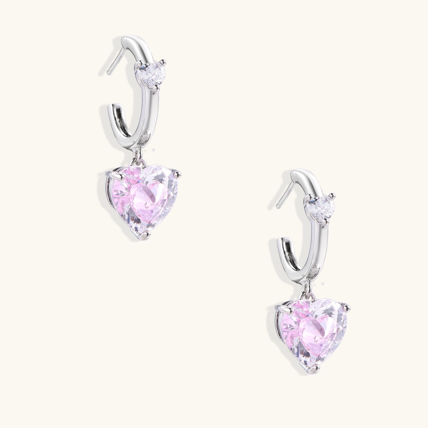 Elegant drop earrings featuring pink heart-shaped zirconia stones with clear accent gems in gold-plated settings
