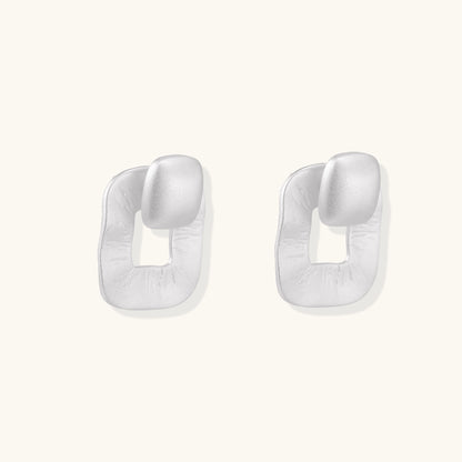 Geometric sterling silver square stud earrings with brushed texture and central square cutouts on white background.