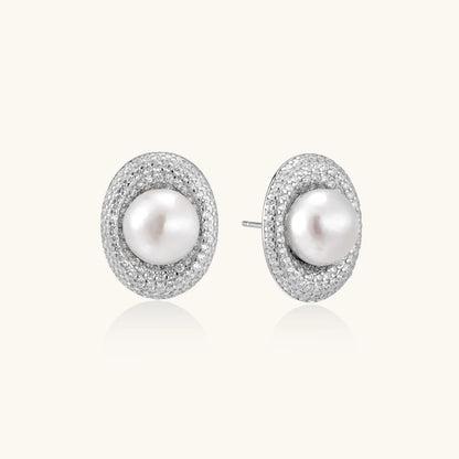 Oval rhodium-plated silver studs featuring freshwater pearls surrounded by pavé crystal halo on white background