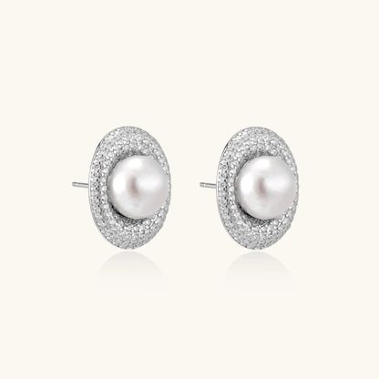 Oval rhodium-plated silver studs featuring freshwater pearls surrounded by pavé crystal halo on white background