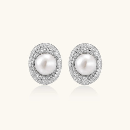 Oval rhodium-plated silver studs featuring freshwater pearls surrounded by pavé crystal halo on white background