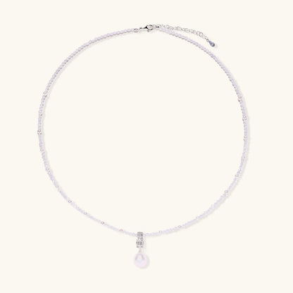 Dainty necklace with lavender crystal beads, freshwater pearls, geometric pendant, and large pearl drop on white background.