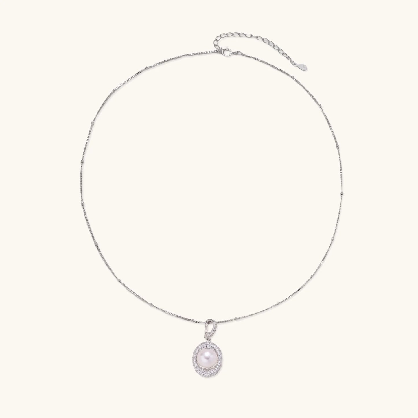 Oval sterling silver pendant with crystal halo surrounding a white freshwater pearl on delicate chain