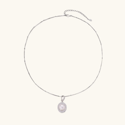 Oval sterling silver pendant with crystal halo surrounding a white freshwater pearl on delicate chain