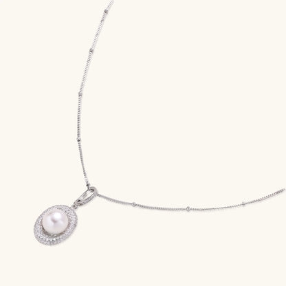 Oval sterling silver pendant with crystal halo surrounding a white freshwater pearl on delicate chain