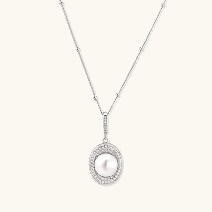 Oval sterling silver pendant with crystal halo surrounding a white freshwater pearl on delicate chain