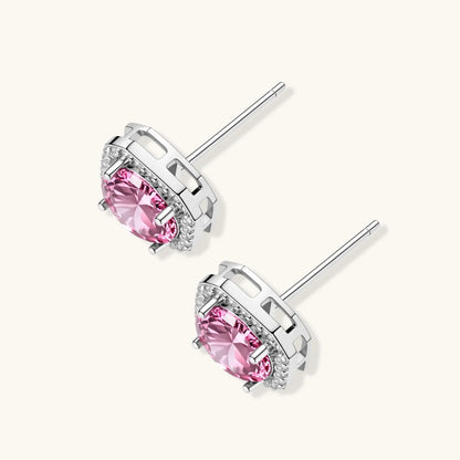 Pink moissanite studs in octagonal sterling silver halo settings with sparkling accent stones on cream background.
