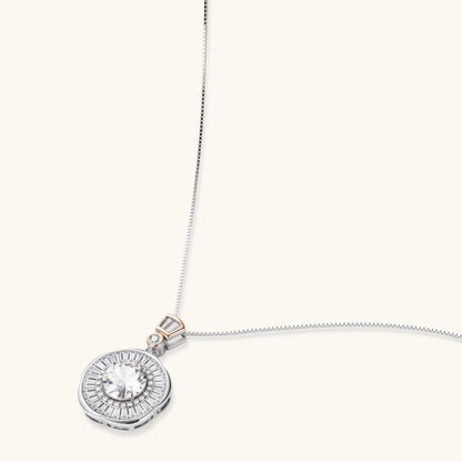 Sterling silver necklace with circular geometric pendant featuring central moissanite and radial baguette pattern.