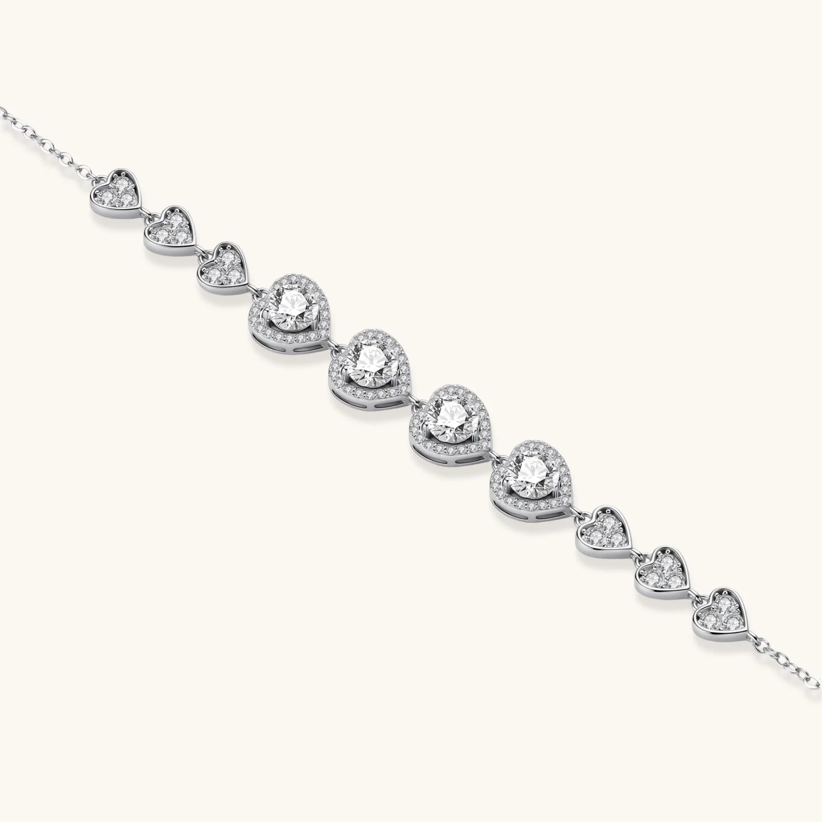 Sterling silver bracelet with graduated heart-shaped links and sparkling moissanite stones in VVS1 clarity on white background.