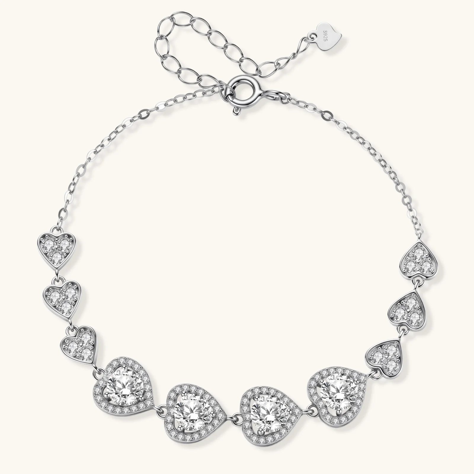 Sterling silver bracelet with graduated heart-shaped links and sparkling moissanite stones in VVS1 clarity on white background.