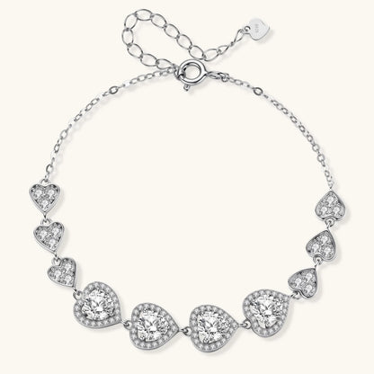 Sterling silver bracelet with graduated heart-shaped links and sparkling moissanite stones in VVS1 clarity on white background.