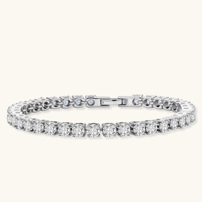 Sterling silver tennis bracelet with continuous row of brilliant moissanite stones and secure clasp closure on cream background.