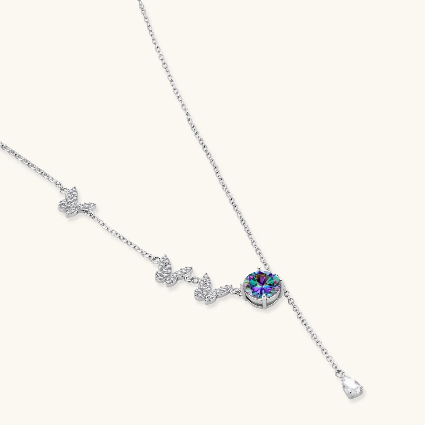 Delicate sterling silver necklace with crystal-set butterfly charms and rainbow moissanite pendant on white background.