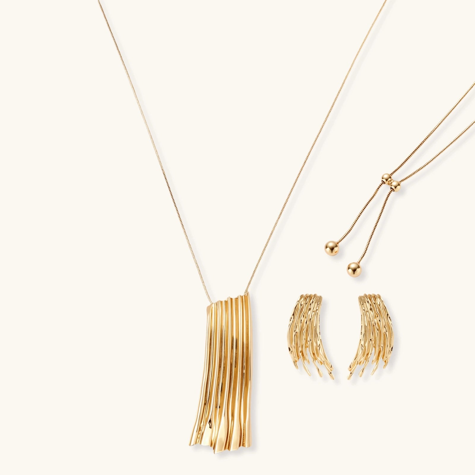 Gold-toned cascade jewelry set with flowing textured strands, featuring drop earrings and matching pendant necklace