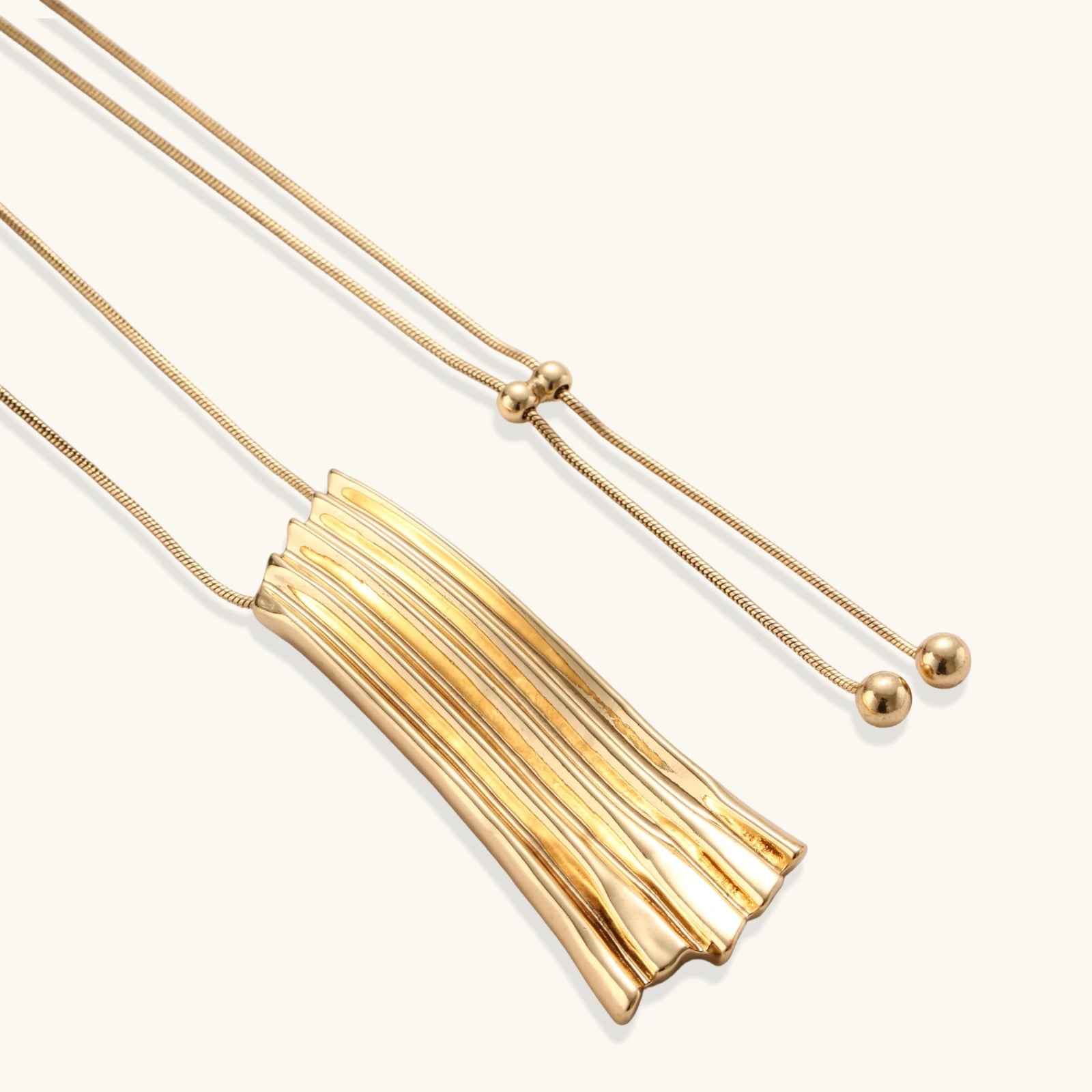 Gold-toned cascade jewelry set with flowing textured strands, featuring drop earrings and matching pendant necklace