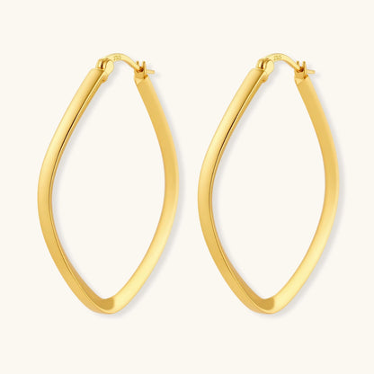 Set of geometric gold-plated sterling silver hoop earrings in oval and cushion shapes on cream background