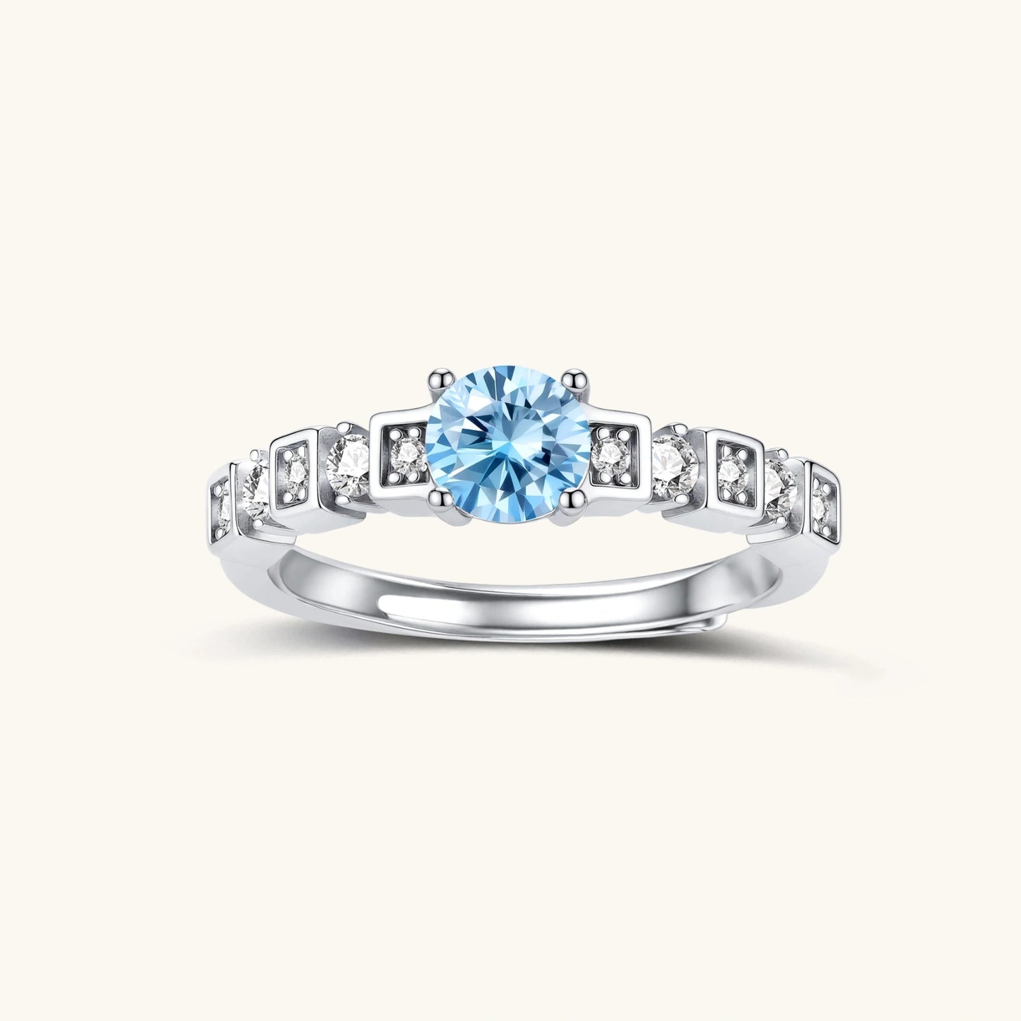 Geometric sterling silver ring with light blue moissanite center stone and square diamond accents on white background