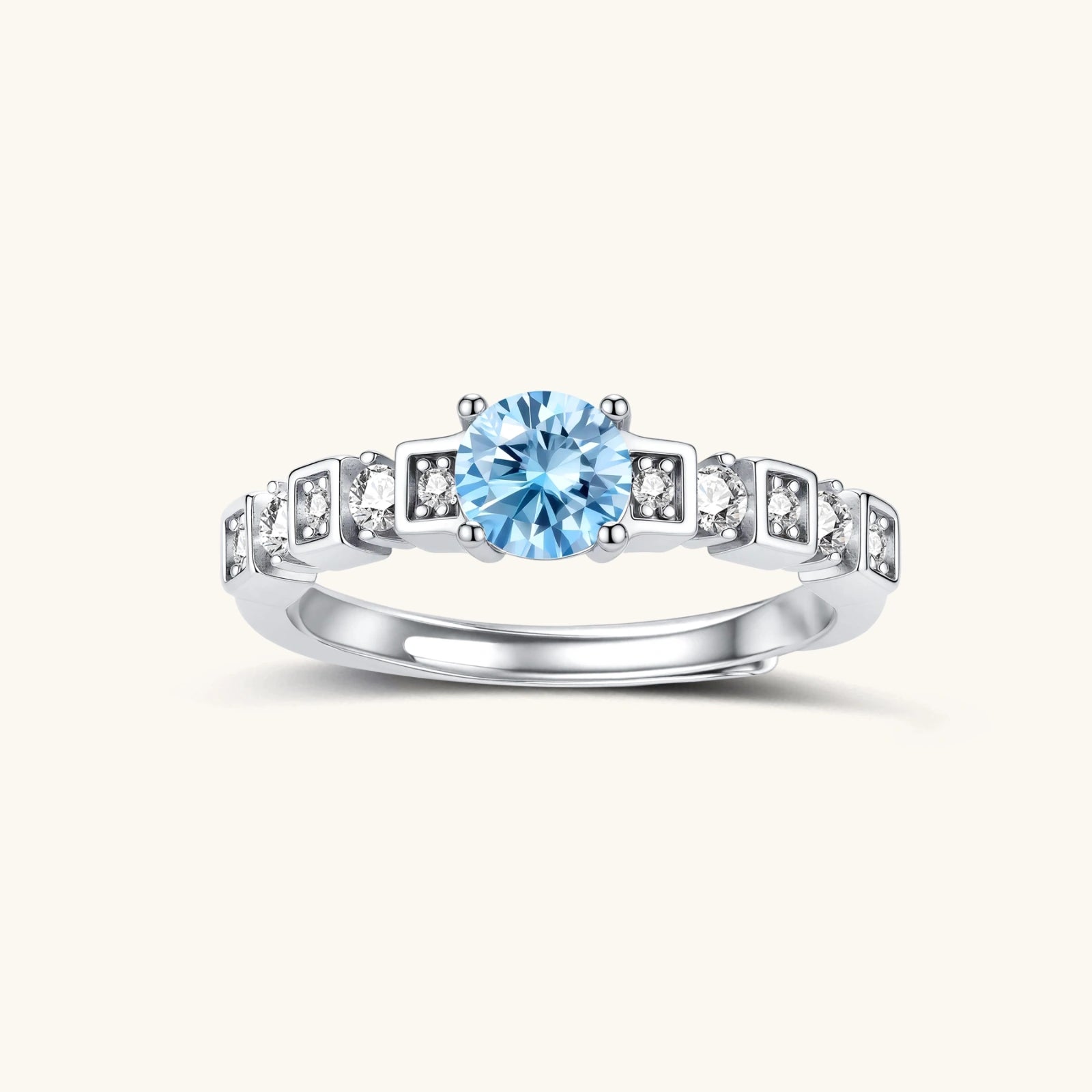 Geometric sterling silver ring with light blue moissanite center stone and square diamond accents on white background