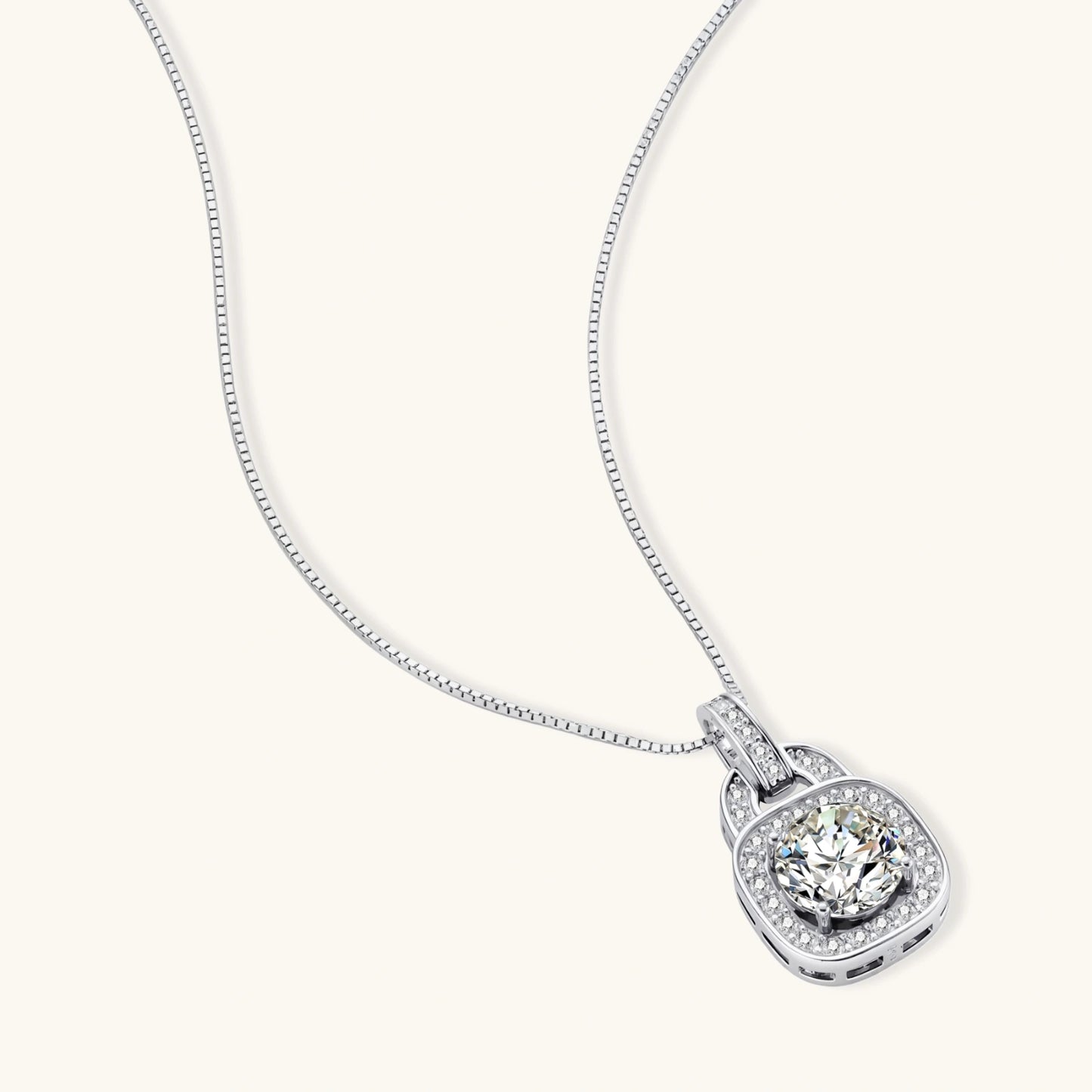Sterling silver cushion halo pendant necklace featuring 2ct moissanite center stone with delicate box chain on neutral background.