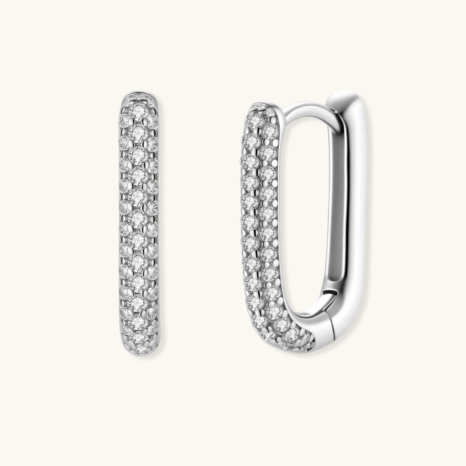 Close-up of platinum-plated sterling silver huggie hoops with pavé crystal setting on white background.