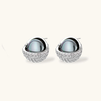 White gold plated spherical jewelry set with zirconia crystal pavé and dark lustrous centers on neutral background.