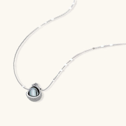 White gold plated spherical jewelry set with zirconia crystal pavé and dark lustrous centers on neutral background.