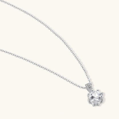 Platinum-plated sterling silver necklace with round clear crystal pendant and decorative bail on neutral background.