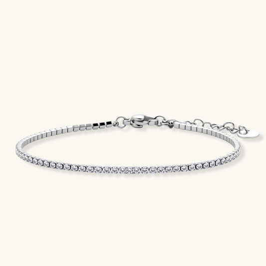 Silver stainless steel tennis bracelet with a single row of clear round zircon stones, lobster clasp, and adjustable extender chain.